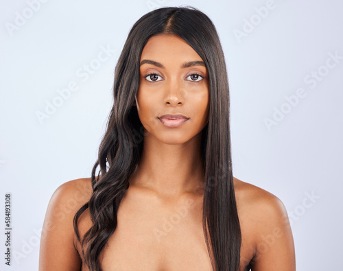 Girl, hair care or beauty in studio portrait for strong, healthy natural shine or wellness on white background. Face of glowing young model, Indian woman or salon spa for curly style in grooming