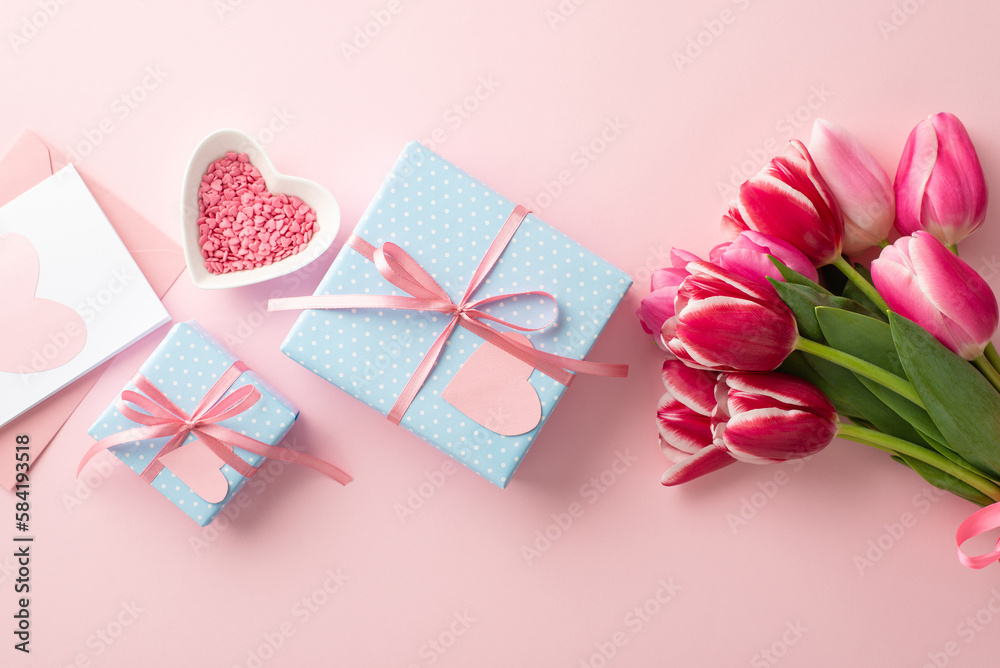 Mother's Day concept. Top view photo of blue gift boxes with ribbon bows bouquet of pink tulips heart shaped saucer with sprinkles and envelope with postcard on isolated pastel pink background