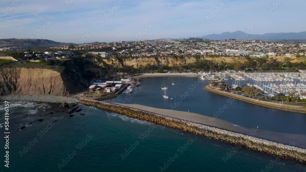 Sweeping panoramic view of luxury ocean side homes, jetty, and boat harbor