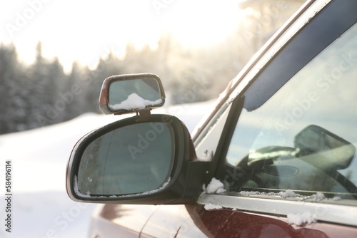 Side view mirror of car on snowy winter day, closeup © New Africa
