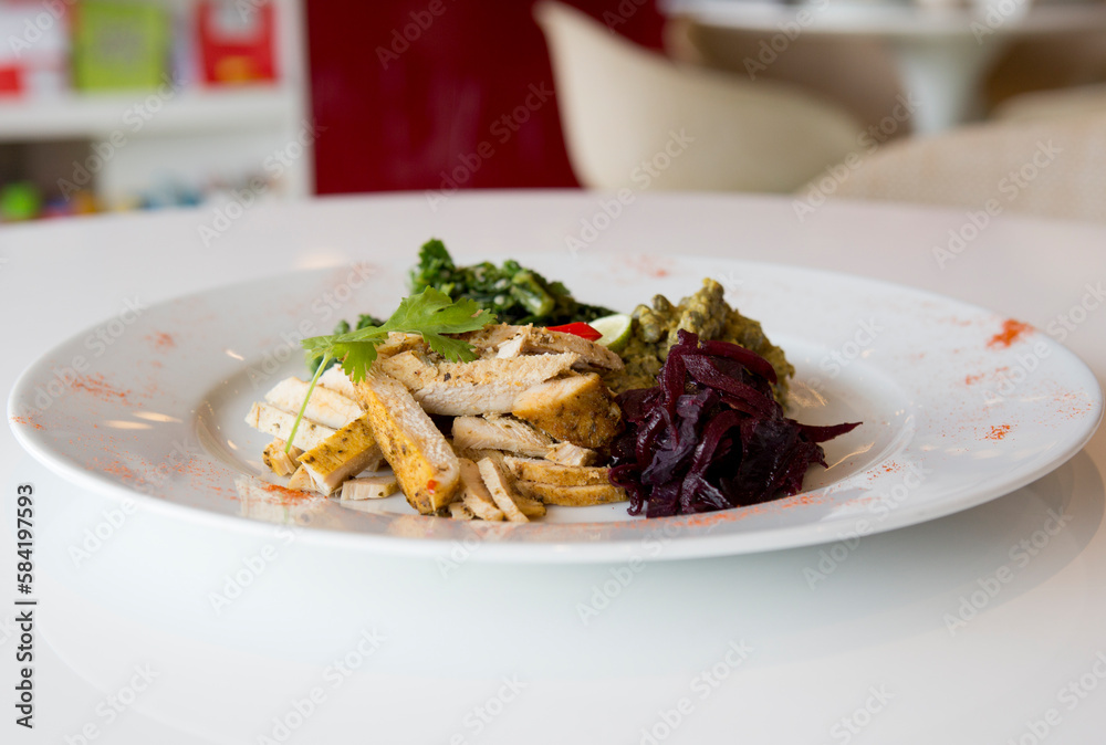 Healthy spicy chicken on a white plate with shredded beetroot & cuscus. Healthy spicy chicken on a white plate with shredded beetroot & cuscus.