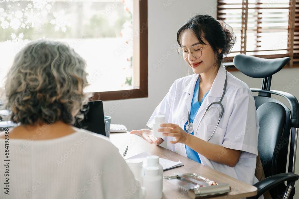 Fototapeta premium Asian Doctor and patient discussing something while sitting at the table . Medicine concept.