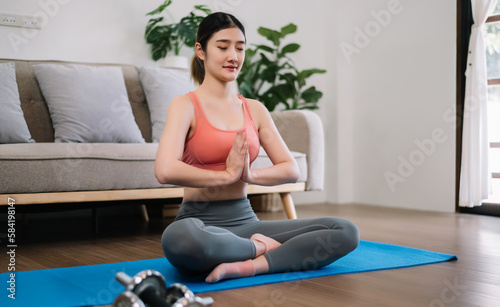 Asian Woman Doing Yoga and Watching Online Tutorials on Laptop, Training in Living Room