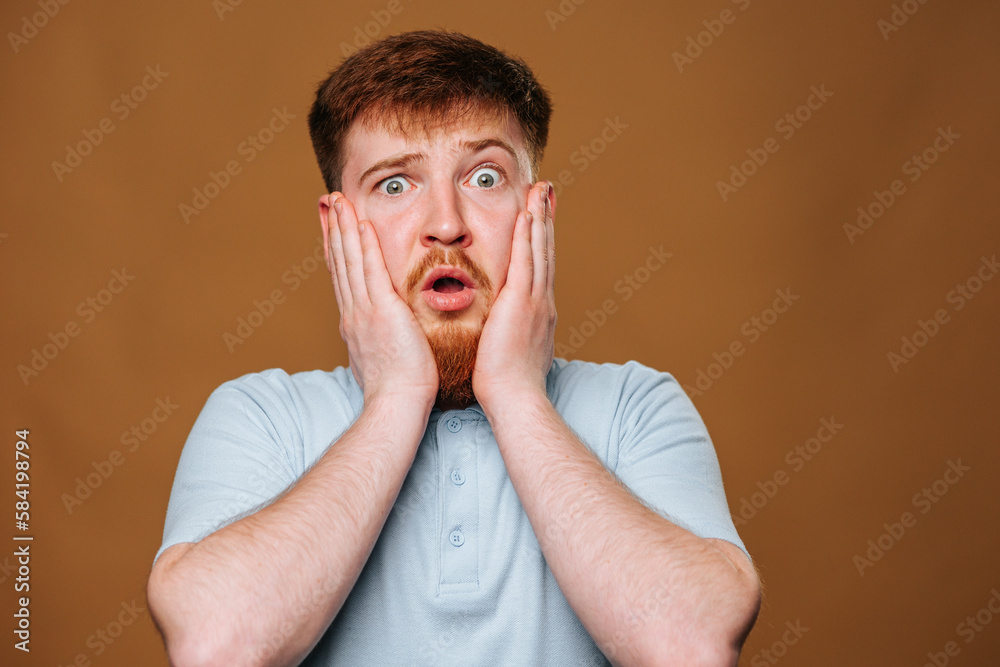 teenage guy looks surprised and amazed as he strikes a pose in front of the camera in a studio teenage guy looks surprised and amazed as he strikes a pose in front of the camera in a studio