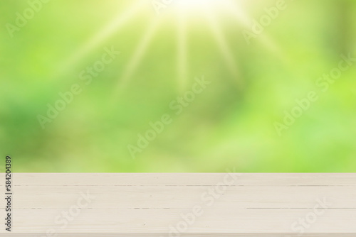 Wooden table top with natural green blurred background or various leaves  fresh bright sunlight  product empty concept.
