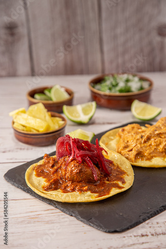 Tacos mexicanos de cochinita pibil y tinga de pollo sobre madera. (ID: 584205544)
