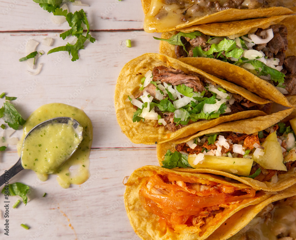 Tacos mexicanos con salsa verde en mesa de madera, tradicional comida