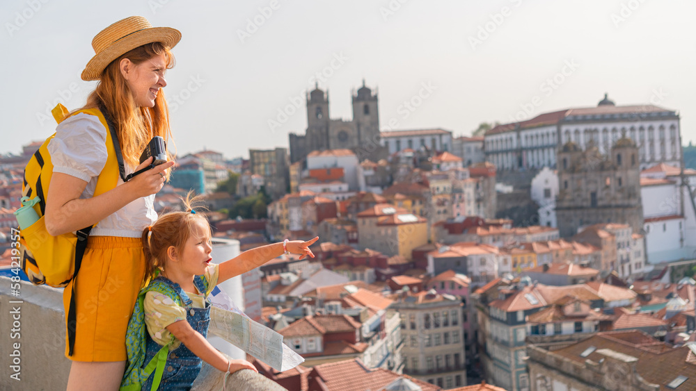 Happy family traveling. Young red-haired mother and little excited daughter looking on the Porto city, Portugal