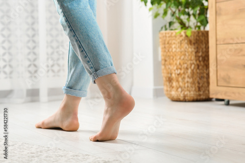 Woman stepping barefoot in room at home, closeup. Floor heating © New Africa