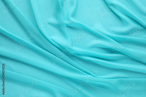 Beautiful turquoise tulle fabric as background, top view