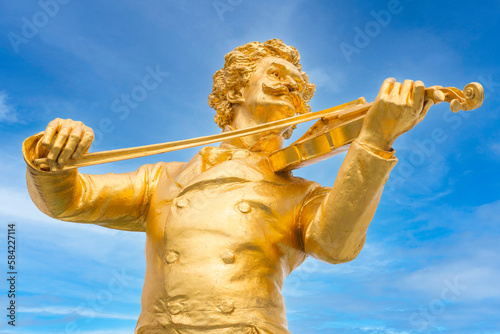Vienna, Austria golden close-up statue of music composer Johann Strauss, playing the violin, in the Stadtpark park photo