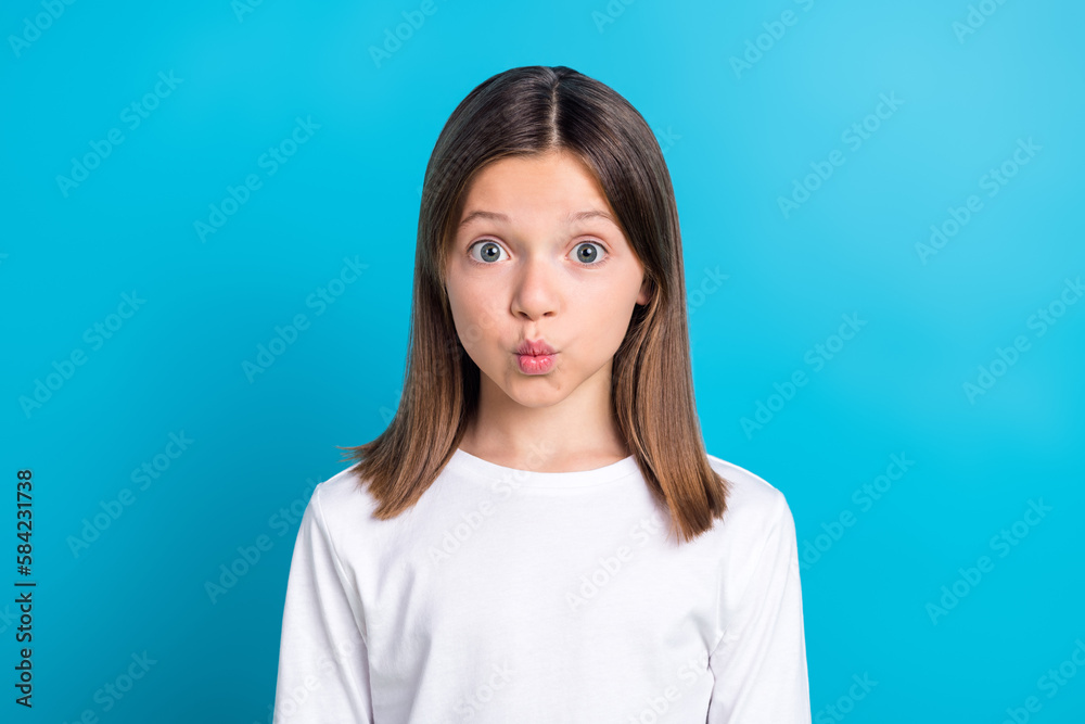 Photo portrait of small schoolkid girl pouted lips kiss wear trendy white garment isolated on blue color background Photo portrait of small schoolkid girl pouted lips kiss wear trendy white garment isolated on blue color background