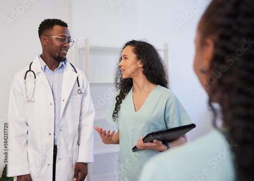 Nurses and doctor standing and discussing patient care at clinic, hospital
