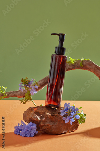 Front view of a glass cosmetic bottle with pumper of Mugwort (Artemisia vulgaris) extract. Natural organic beauty cosmetics concept