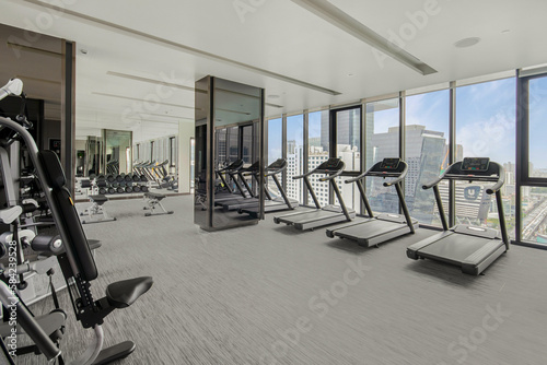 Modern gym interior with sport and fitness equipment overlooking building view , fitness center interior, interior of crossfit