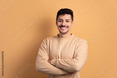 happy brazilian man with arms crossed in studio shot. portrait, real people concept.