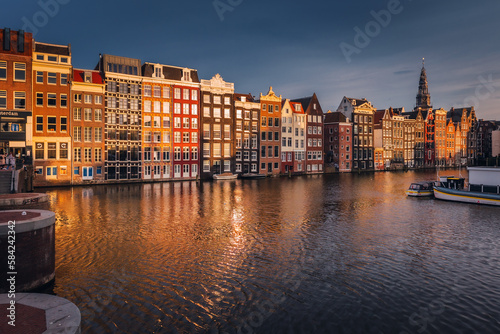 Canals in Amsterdam - the capital of the Netherlands in a night scenery. The huge amount of colors adds a beautiful look to this architecture. #584242342