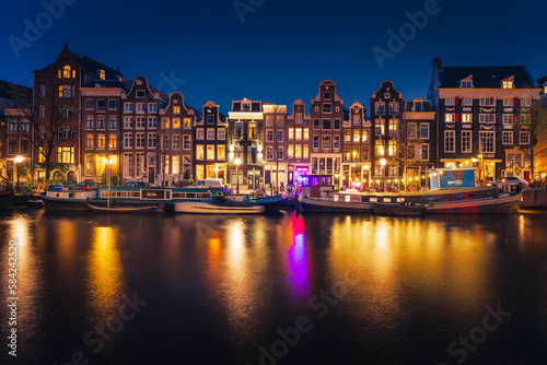 Canals in Amsterdam - the capital of the Netherlands in a night scenery. The huge amount of colors adds a beautiful look to this architecture.