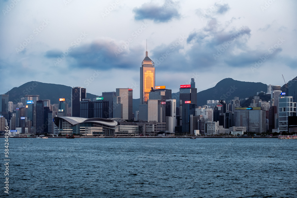 Obraz premium Golden sunset lights up the Central Plaza at Victoria Harbour, Hong Kong.