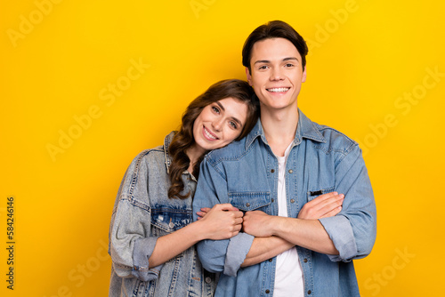 Portrait of two positive friendly people toothy smile crossed arms hug isolated on yellow color background