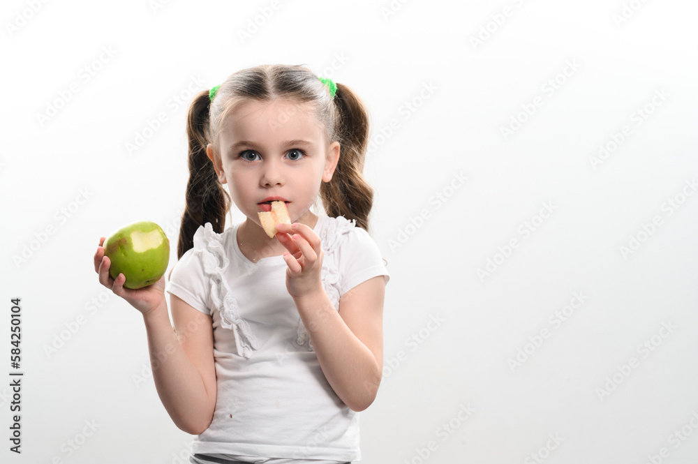 A little girl is holding one apple and chips on a white background. A little girl is holding one apple and chips on a white background.