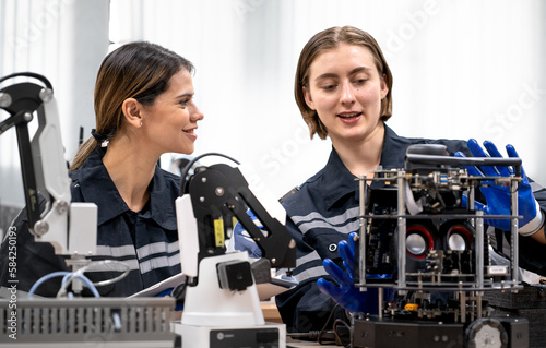Engineer woman working on AI technology in robotics and electronics engineering laboratory. University students' research project is programming robot machine with intelligent mechanical control