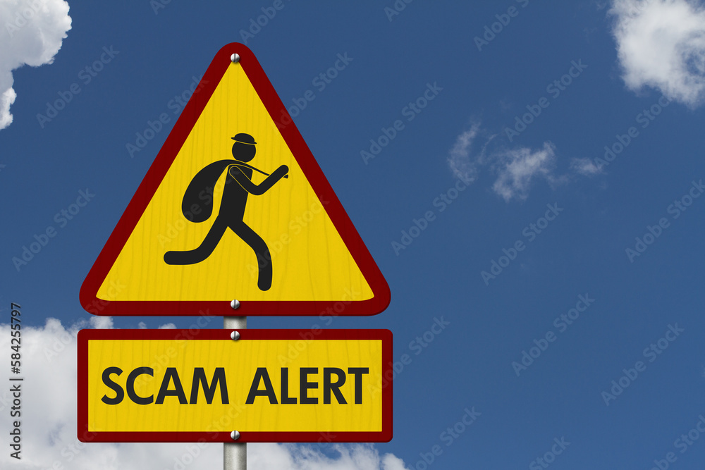 Scam Alert message on warning road sign on sky Scam Alert message on warning road sign on sky