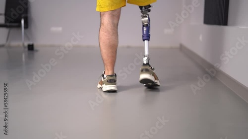 Crop man with prosthetic leg walking in studio