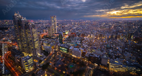 Tokyo Japan skyline under a cloudy sky taken soon after sunset with buildings lit up