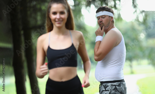 Man emotionally looks at beautiful athletic girl in park