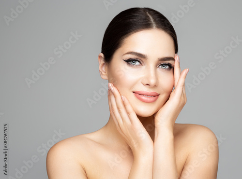 Face Skin Care. Beauty Woman with Full Lips Natural Makeup over Gray. Beautiful Model Facial Massage. Facelift Plastic Surgery and Dermal Filler Cosmetology