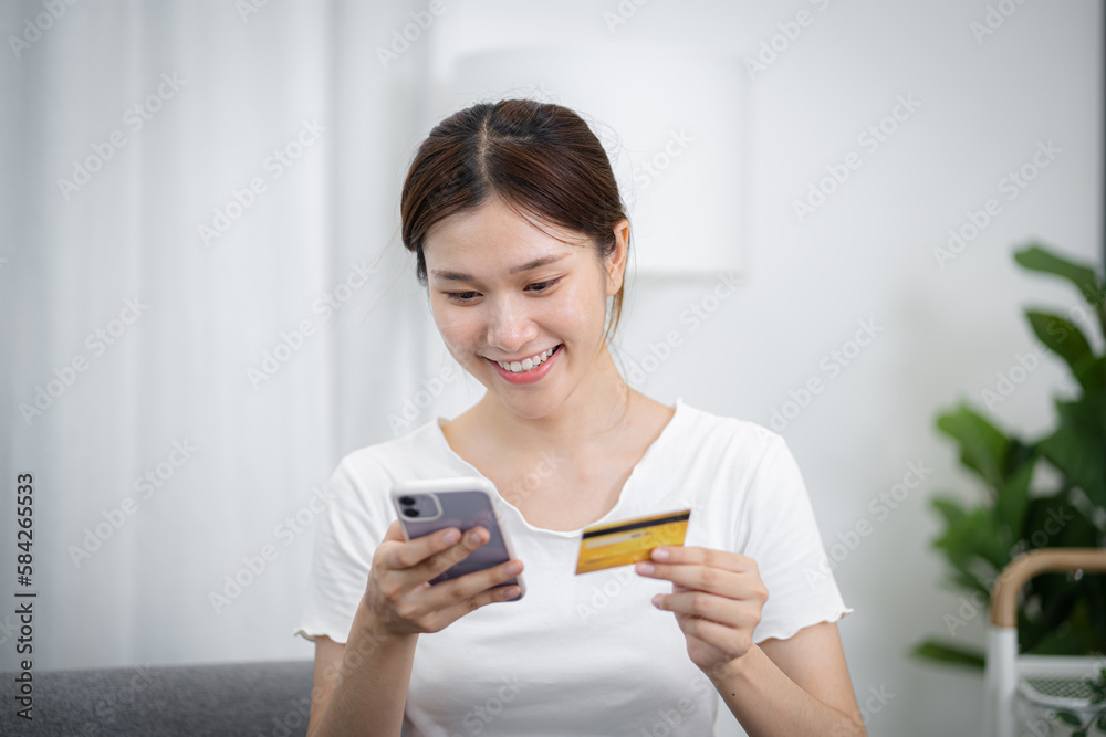 Woman shopping on Smartphone holding credit card for Internet online e-commerce shopping spending money Online shopping Mobile phone concept Woman shopping on Smartphone holding credit card for Internet online e-commerce shopping spending money Online shopping Mobile phone concept