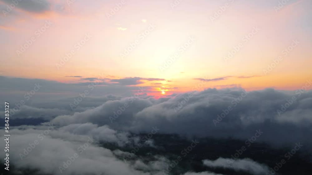 Aerial view of sun rising above the clouds. The sky is reddish orange. Sunrise above the clouds - High altitude shot Aerial view of sun rising above the clouds. The sky is reddish orange. Sunrise above the clouds - High altitude shot