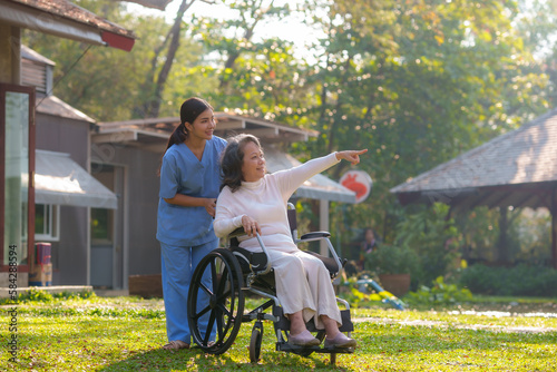 Wallpaper Mural Asian nurse takes a patient in a wheelchair to make her feel refreshed and relaxed at the park. Torontodigital.ca