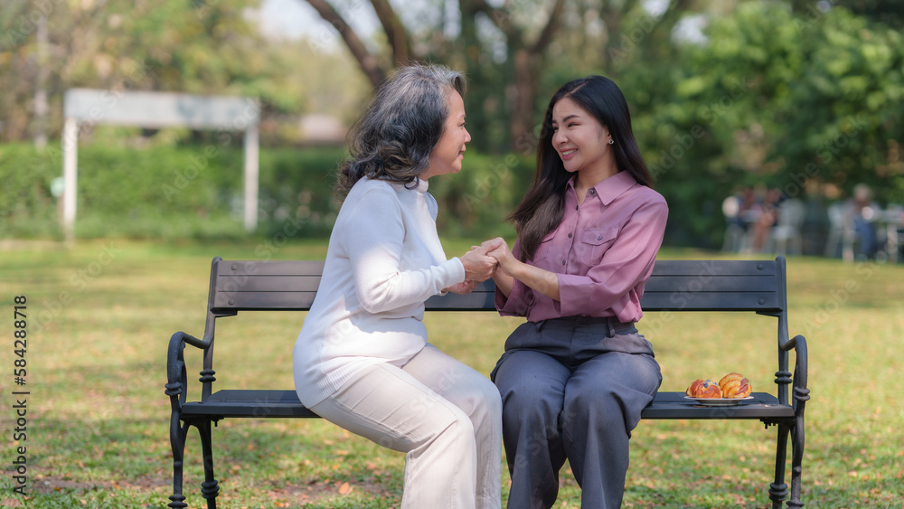 Asian mother and daughter sitting in the park happily and warmly. Asian mother and daughter sitting in the park happily and warmly.