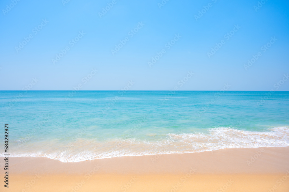 Light blue sea waves on clean sandy beach.