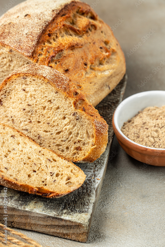 Fresh bread with seeds, sesame cut into pieces on a cutting board. vertical image. top view. place for text Fresh bread with seeds, sesame cut into pieces on a cutting board. vertical image. top view. place for text