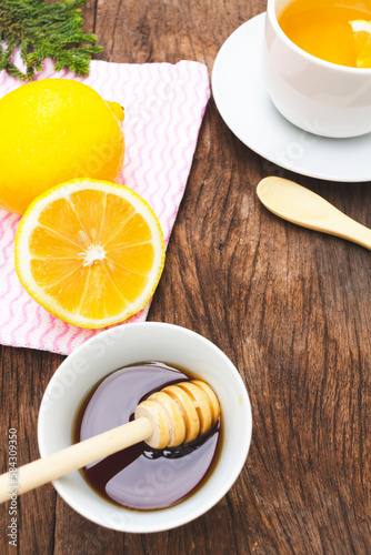 Tea with lemon and honey on the wooden background.
