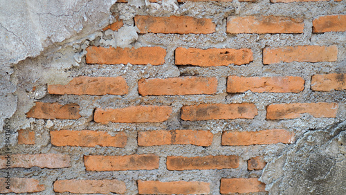 Close up of a weathered brick and stucco plaster wall. Background of brick wall texture.
