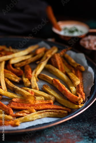 Healthy homemade oven baked sweet potato and carrot fries served with yogurt and green onion sauce. Low calorie vegetarian snack