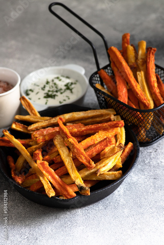 Healthy homemade oven baked sweet potato and carrot fries served with yogurt and green onion sauce. Low calorie vegetarian snack
