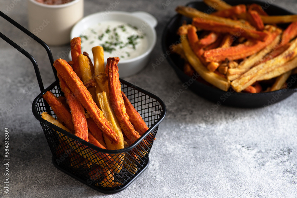 Healthy homemade oven baked sweet potato and carrot fries served with