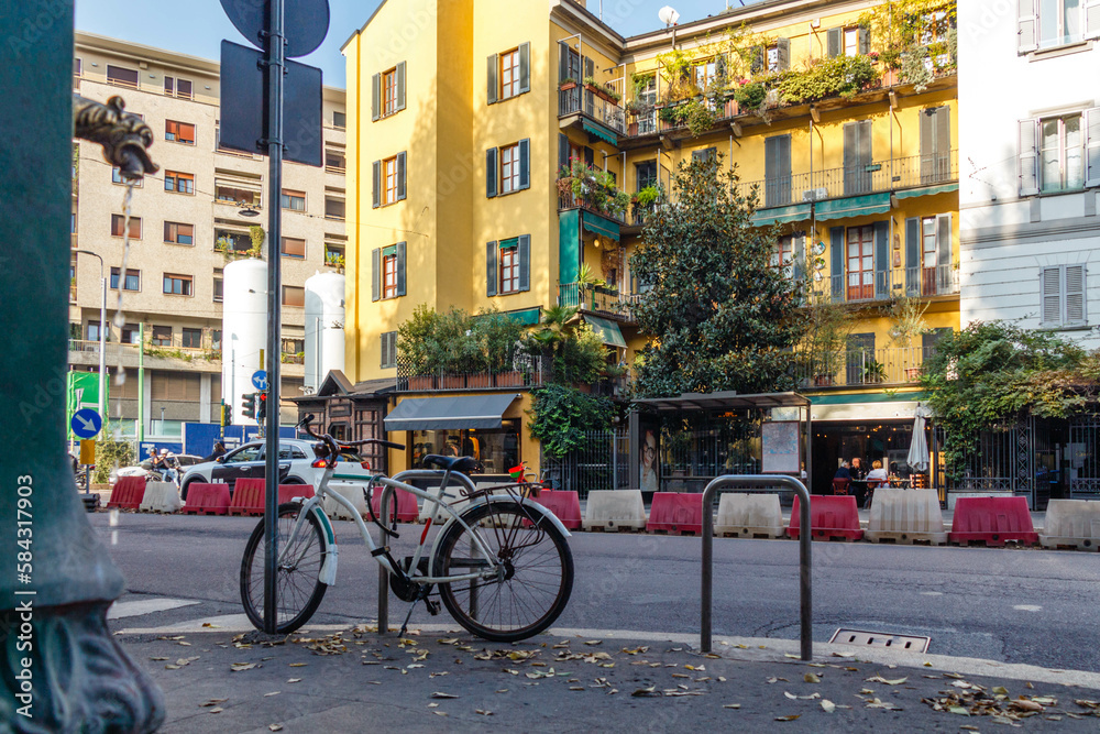 Milan street view: drinking fountain, bicycle, bright building facade