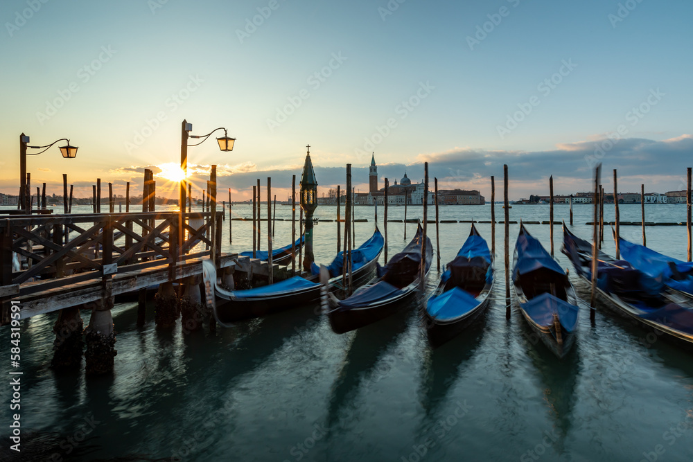 Venice  gondala's Italy. Sunrise in Venice with gondala's in the foreground on the canal and the sunrise in the backgound on blue sky.