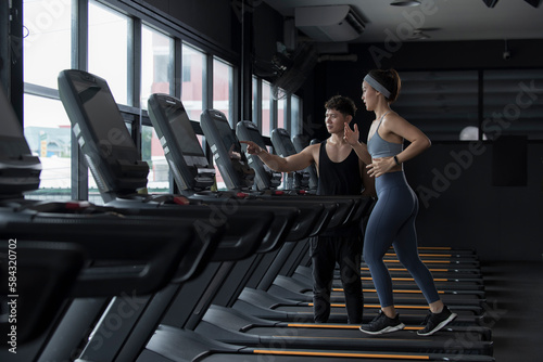 person exercising in gym. woman exercising in gym. Sportswoman on training while running on treadmill machine in the gym. Happy and positive people workout.