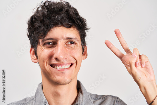 Young man with strabismus smiling positively at the camera.