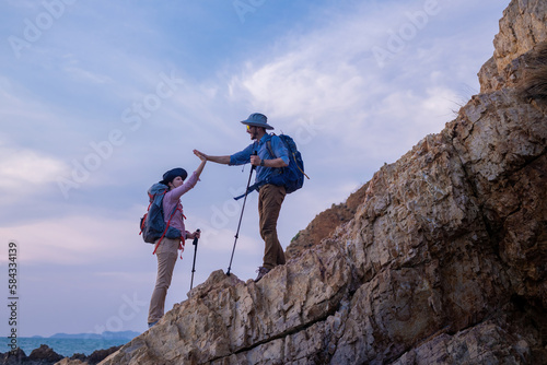 Tourists with backpacks hike on rocky top mountain trekking is adventure sport for Traveller who love hiker on summer holidays trekking and activity.