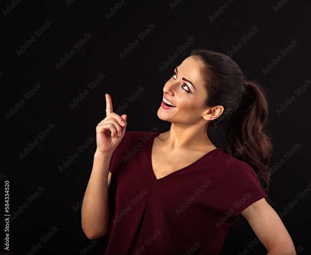 Beautiful excited makeup woman with long brown healthy hair style looking up and showing the hand with finger up. Healthy lifestyle and success business. Closeup portrait Beautiful excited makeup woman with long brown healthy hair style looking up and showing the hand with finger up. Healthy lifestyle and success business. Closeup portrait