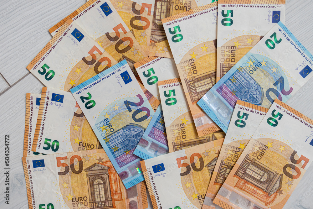 Euro money banknotes. Bundle of 50 and 20 euro bills on white wooden background. Flat lay of euros banknotes Euro money banknotes. Bundle of 50 and 20 euro bills on white wooden background. Flat lay of euros banknotes