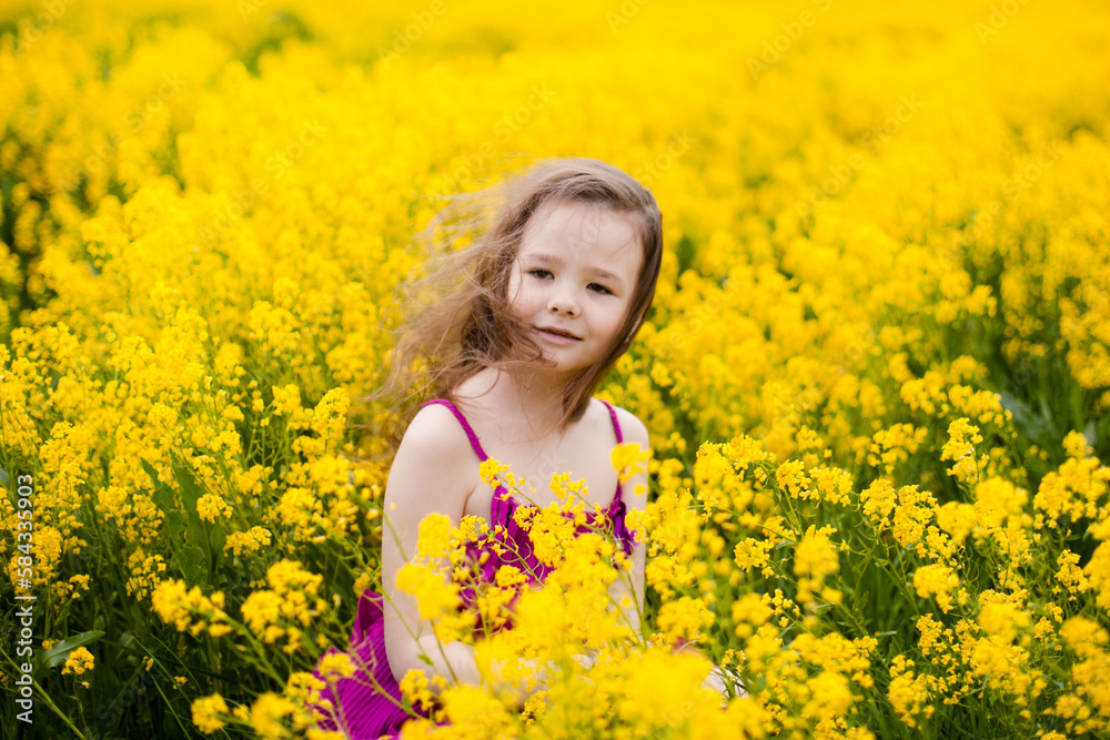 Girl in a pink dress in a field with yellow flowers Girl in a pink dress in a field with yellow flowers
